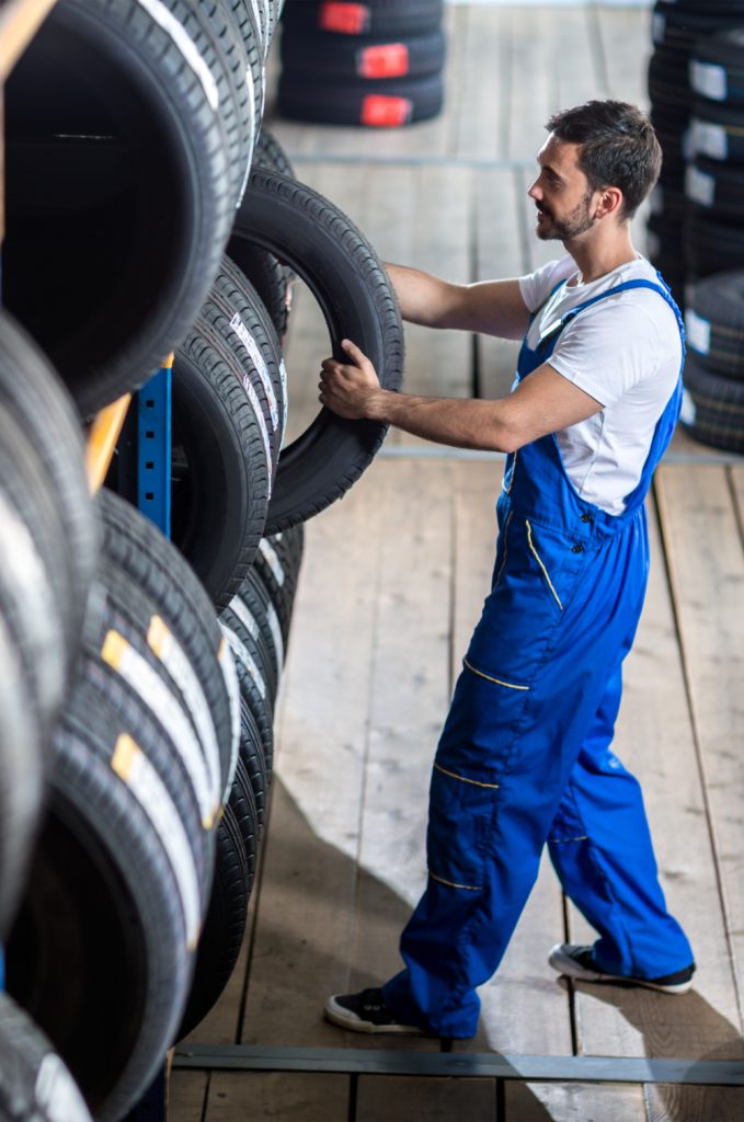 Mechanic picking up a tyre from stock - Tyres Holderness